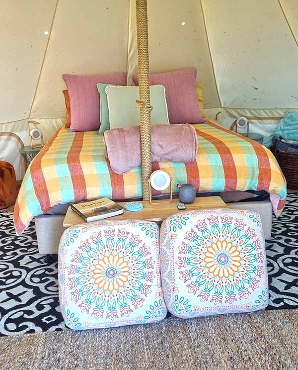 A queen sized bed inside the bell tent